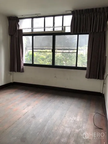 Shophouse for rent - Bright room with large curtained window facing greenery and aged wood floors.