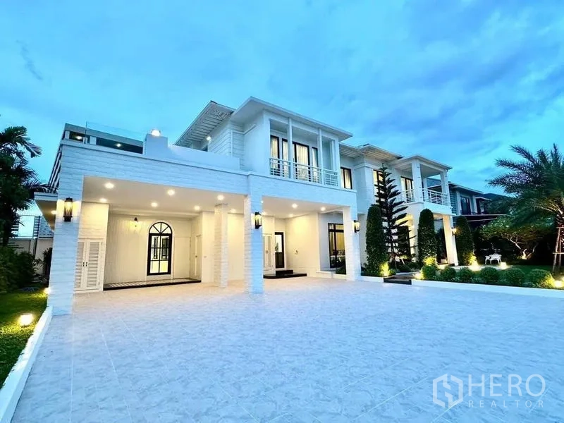 Detached House for rent in Bang Phli, Samut Prakan - Twilight exterior of a two-storey white detached house with wide tiled driveway and manicured garden in Bang Phli.