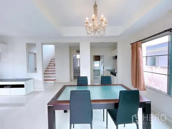Detached House for rent in Bang Na, Bangkok - Open dining area with chandelier and white walls beside the staircase.