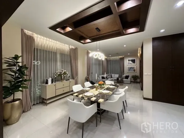 Detached House for rent - Elegant dining room with a marble-top table, eight white chairs and a sculptural chandelier.