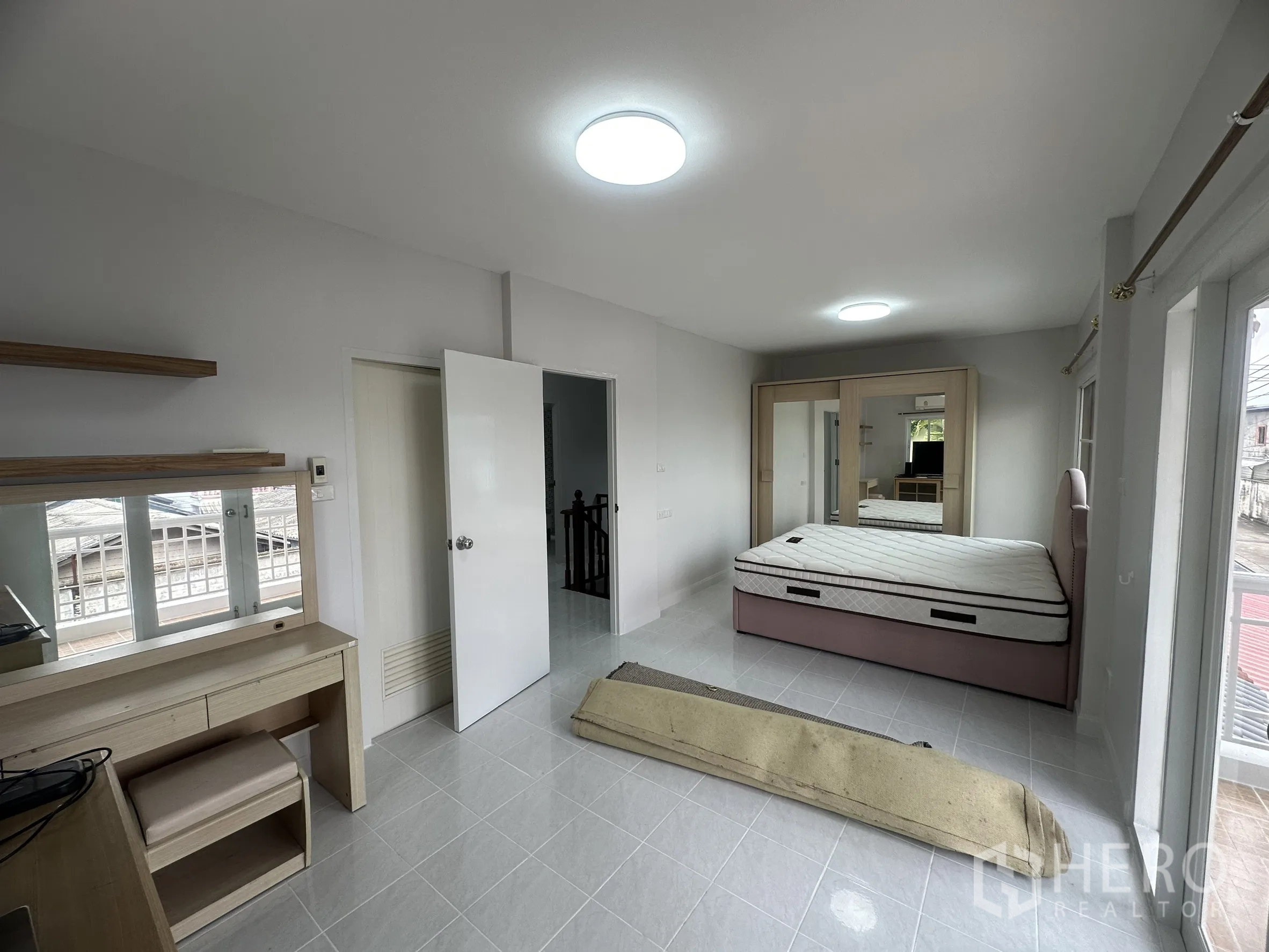 Townhouse for sale in Lam Luk Ka, Pathum Thani - Large master bedroom with vanity, wardrobe and king bed.
