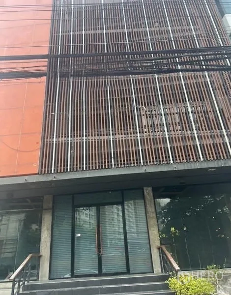 店屋 出租 - 现代多层店屋外立面，竖向金属格栅与玻璃入口，带台阶的街景。