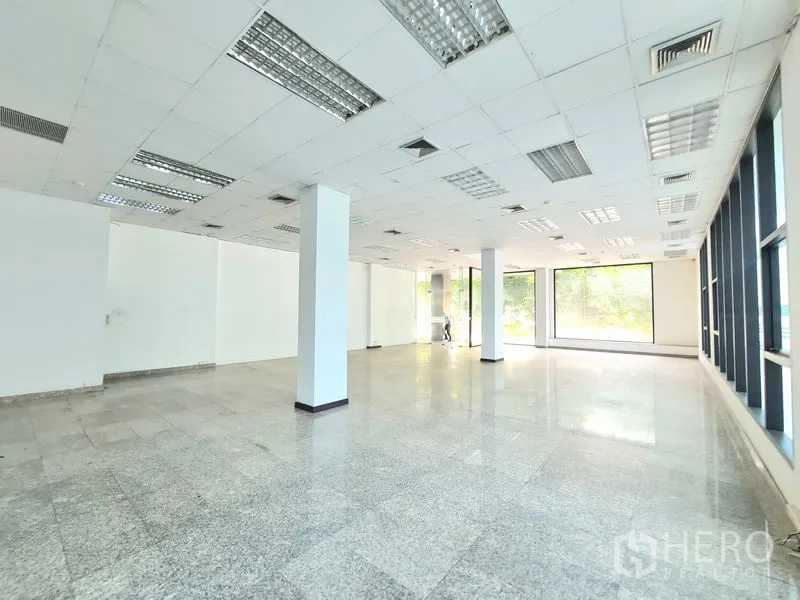 Retail Space for rent in Sathon, Bangkok - Open-plan retail floor with central pillars, reflective stone flooring, and full-height street-facing windows bringing in natural light.