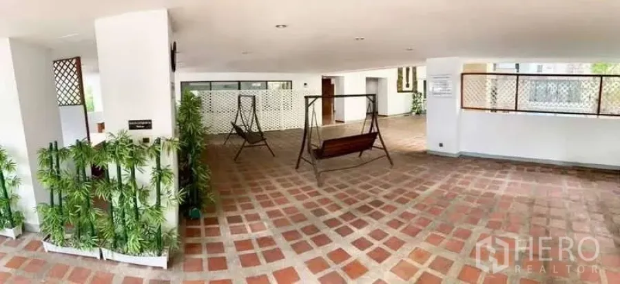 Retail Space for rent in Watthana, Bangkok - Covered semi-open space with checker brick tiles, metal swing seats, planters and white columns suitable for retail use.