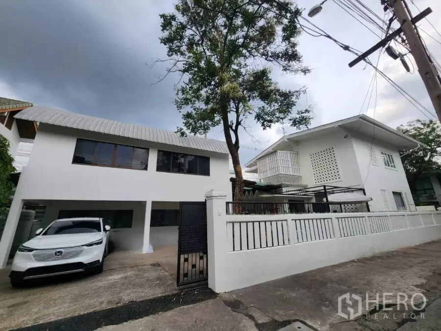 Detached House for rent in Chatuchak, Bangkok - White two-storey detached house with gated driveway and covered carport in Chatuchak.