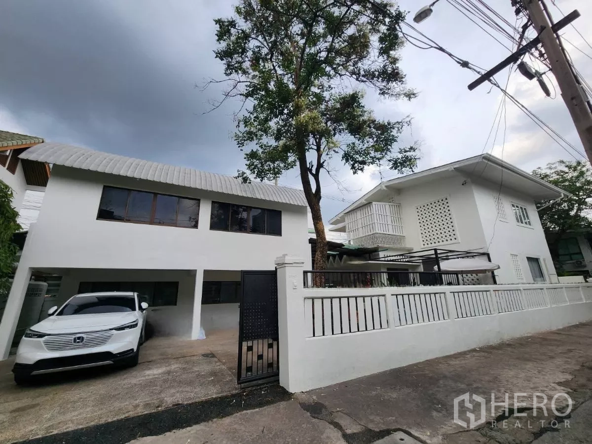 Detached House for rent in Chatuchak, Bangkok - White two-storey detached house with gated driveway and covered carport in Chatuchak.