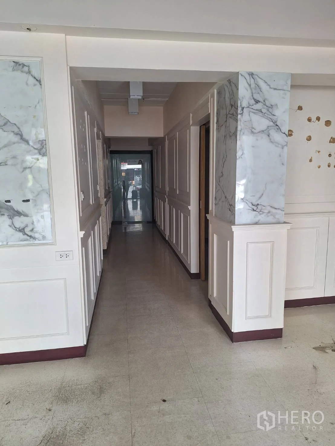 Retail Space for rent in Watthana, Bangkok - Long corridor with white wainscoting and marble columns leading to back rooms.