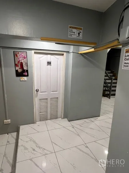 Retail Space for rent in Khlong Toei, Bangkok - Interior corridor with low ceiling warning signs, service door and stair access.
