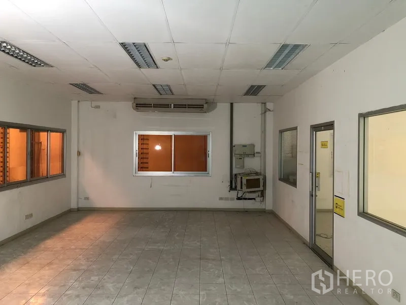 Factory for rent or sale in Khlong Luang, Pathum Thani - Spacious office or control room with air-conditioning, internal windows and drop ceiling lighting.