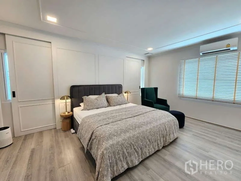 Detached House for rent or sale in Bang Phli, Samut Prakan - Spacious master bedroom with king bed, wood floors, bedside lamps and large windows.