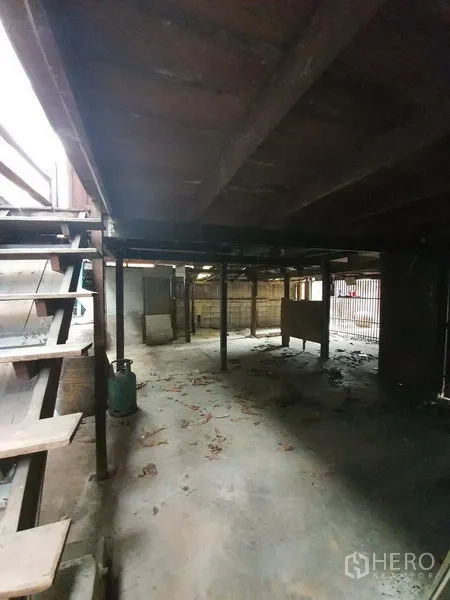 Detached House for rent in Sathon, Bangkok - Shaded ground level under a raised wooden house with concrete floor and stairs.