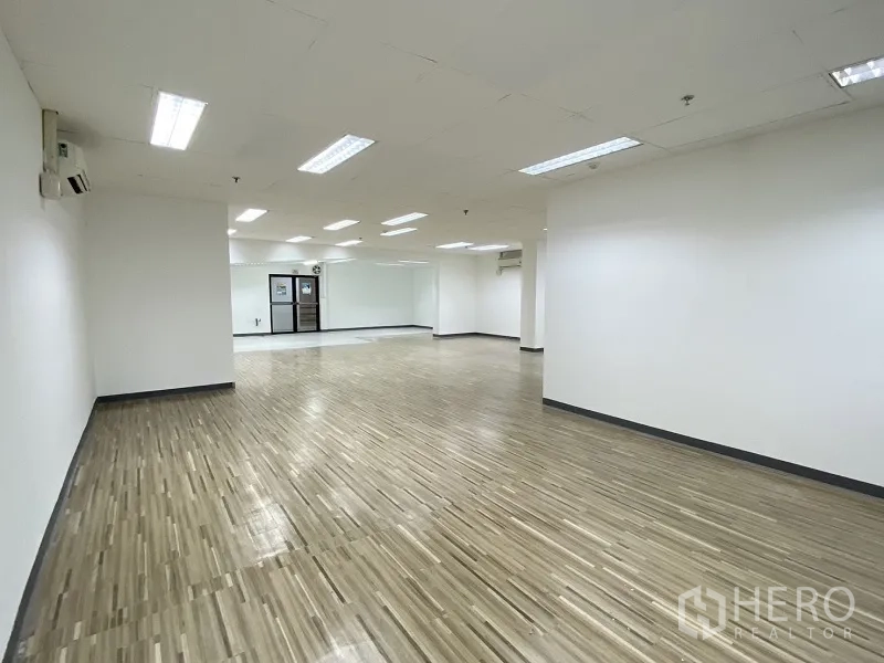Retail Space for rent in Khlong Toei, Bangkok - Open-plan retail interior with wood-look flooring, white walls, and recessed ceiling lights.