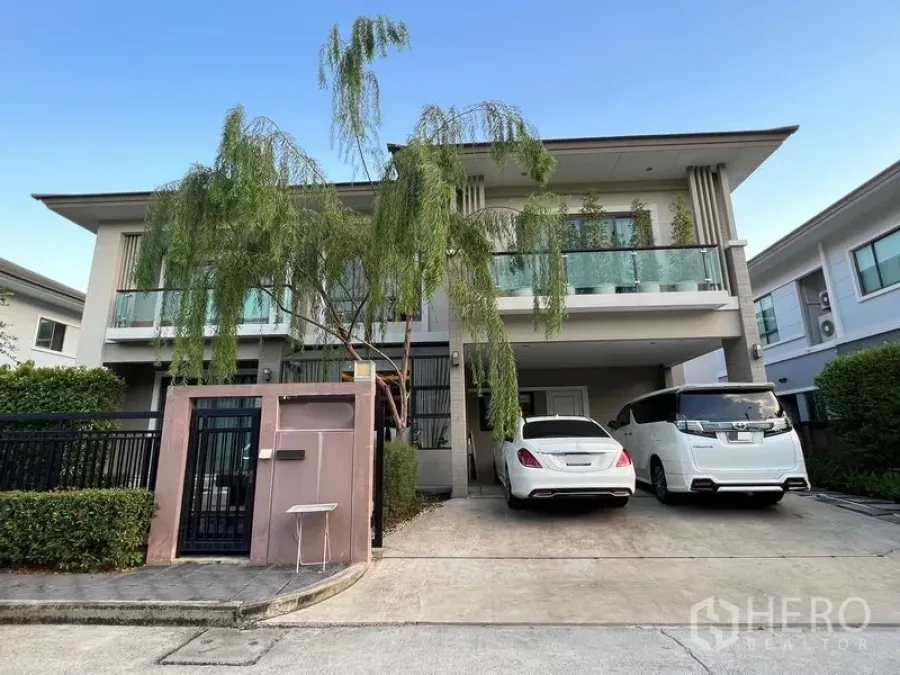 独立式住宅 出租在Suan Luang, Bangkok - 现代两层独栋别墅正面，双车位车库与玻璃阳台。