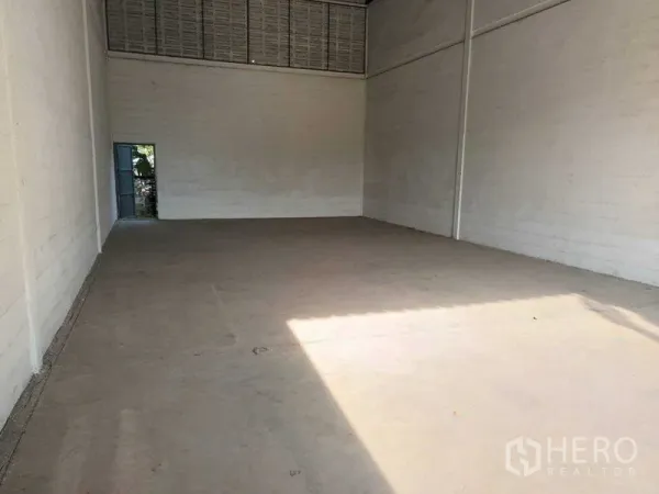 Warehouse for rent in Bang Phlat, Bangkok - Empty warehouse interior with high ceiling, concrete floor and side access door in Bang Phlat, Bangkok.