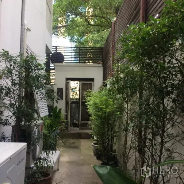 独立式住宅 出租在Sathon, Bangkok - 绿植环绕的侧院步道，通向这栋沙吞独栋别墅的安全大门。