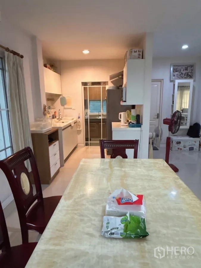 Detached House for sale in Bang Kapi, Bangkok - Dining area connected to a bright pantry kitchen with storage and appliances.