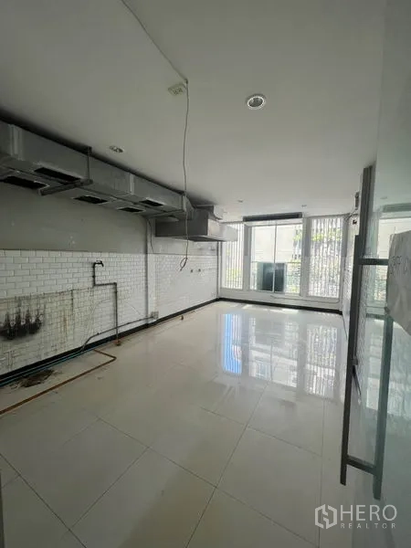 Shophouse for rent in Khlong Toei, Bangkok - Partially fitted kitchen area with white subway tiles, ventilation hoods and large windows.