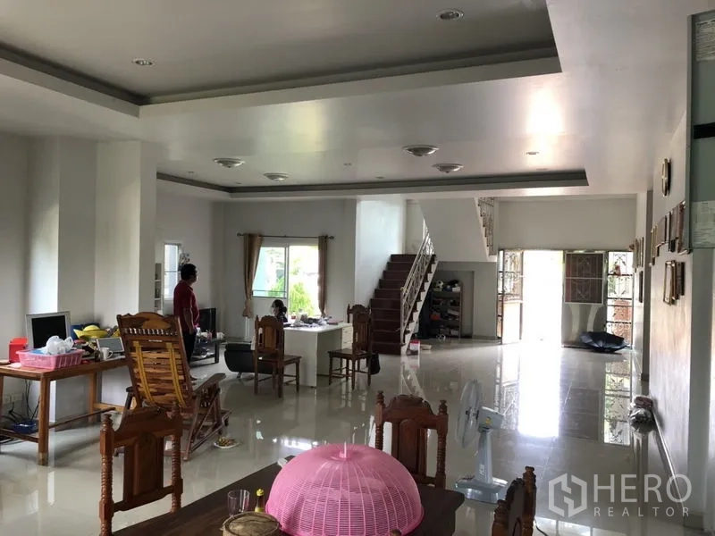 Detached House for sale in Lam Luk Ka, Pathum Thani - Large living and dining space with staircase and multiple windows.