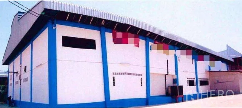 Factory for sale in Samut Prakan - Side elevation of the factory building with insulated wall panels and metal roof.