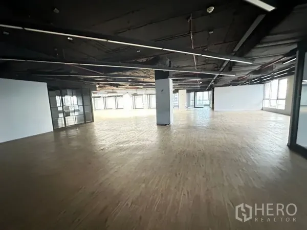 Office Space for rent in Bang Rak, Bangkok - Expansive open-plan office floor with surrounding windows and wood-style flooring.