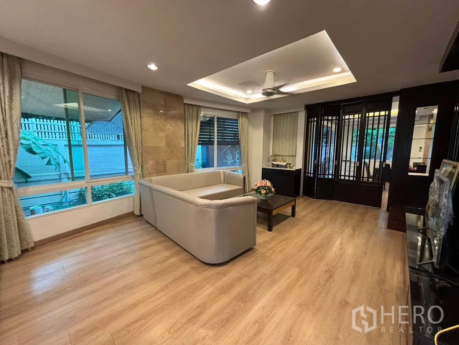 Detached House for rent in Bang Kapi, Bangkok - Living area with recessed ceiling lights and dark wood partition.