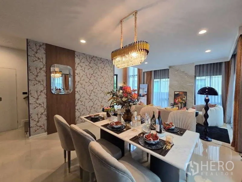 Detached House for rent in Bang Kapi, Bangkok - Dining zone with marble table and statement chandelier beside a feature wall.