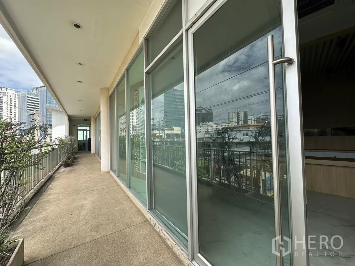Retail Space for rent in Phra Khanong, Bangkok - Glass‑front retail entrance along open air walkway with urban skyline views.