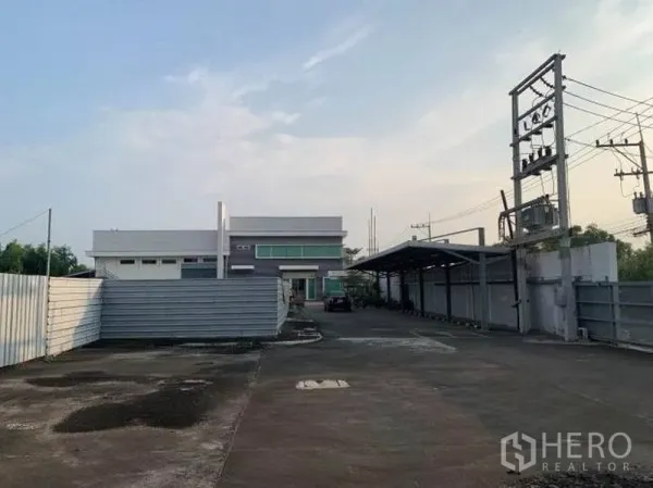 Factory for rent or sale in Wang Noi, Phra Nakhon Si Ayutthaya - Gated driveway with covered parking and onsite power infrastructure.