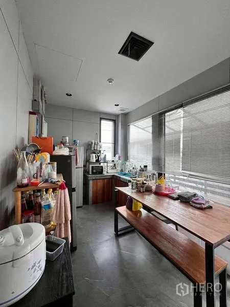Warehouse for rent in Prawet, Bangkok - Staff pantry with sink, shelving, appliances, and dining bench.