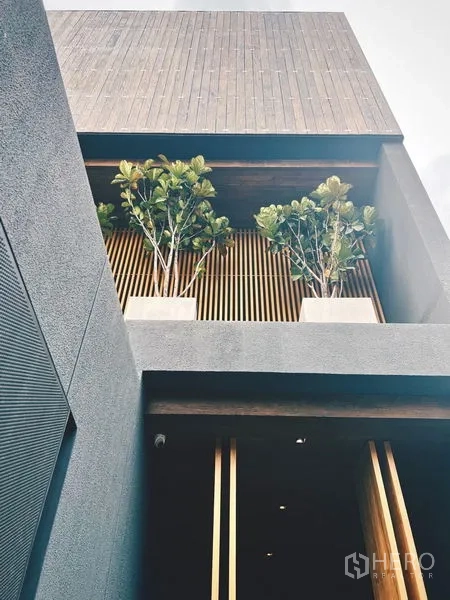 Detached House for rent or sale in Bangkok - Close-up of textured facade with vertical slats and balcony planters.