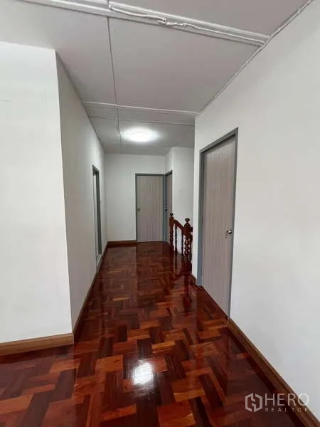 Detached House for rent in Bang Na, Bangkok - Upstairs corridor with polished parquet floor and multiple bedroom doors.