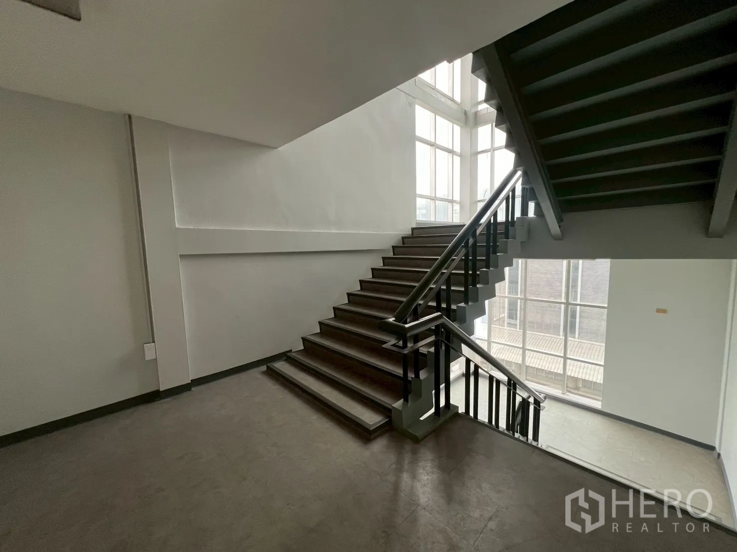 Office Space for rent in Watthana, Bangkok - Well-lit stairwell with large glass windows and metal handrails.