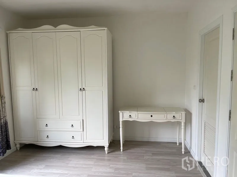 Townhouse for rent in Bang Kapi, Bangkok - Bedroom corner with classic white wardrobe and writing desk.