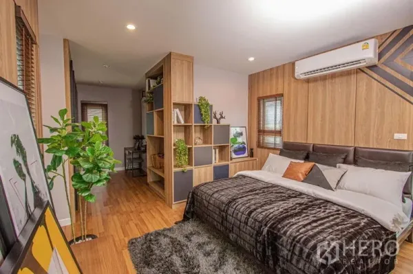 Detached House for sale in Lam Luk Ka, Pathum Thani - Cozy bedroom suite with divider bookshelf, warm wood flooring and window blinds.