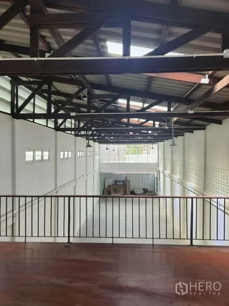 Shophouse for rent in Khlong Toei, Bangkok - View from mezzanine over large warehouse-style showroom with exposed rafters.