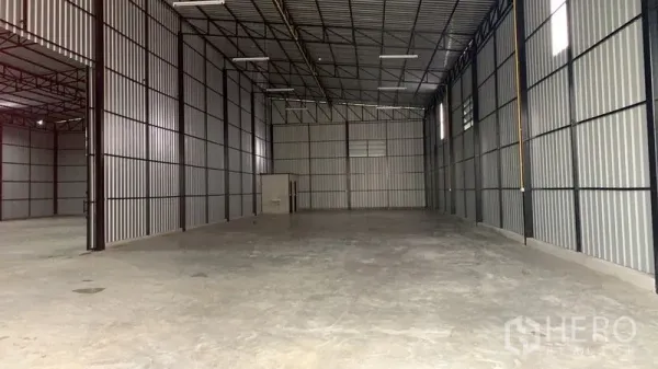 Warehouse for rent in Khan Na Yao, Bangkok - Spacious warehouse interior with high steel truss ceiling, bright strip lighting, and polished concrete floor.