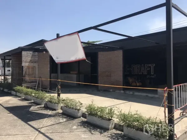 Retail Space for rent in Khlong Toei, Bangkok - Brick-and-wood storefront with steel canopy frame, planter boxes and on-site parking area.