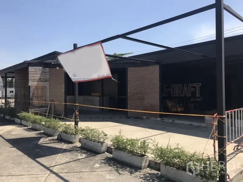 Retail Space for rent in Khlong Toei, Bangkok - Brick-and-wood storefront with steel canopy frame, planter boxes and on-site parking area.