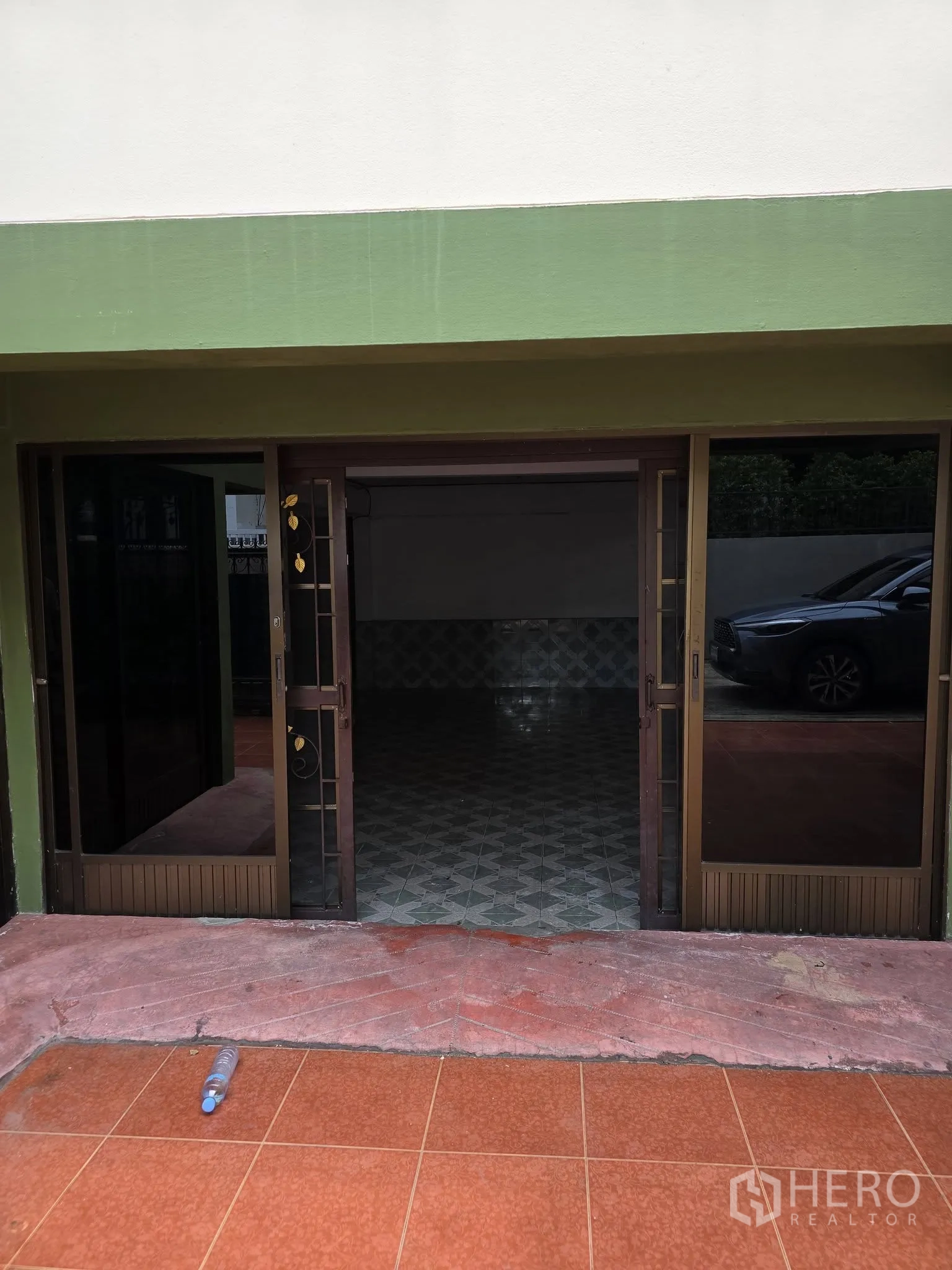 Home Office for rent in Wang Thonglang, Bangkok - Front courtyard with tiled driveway, iron gate and an upper-floor balcony.