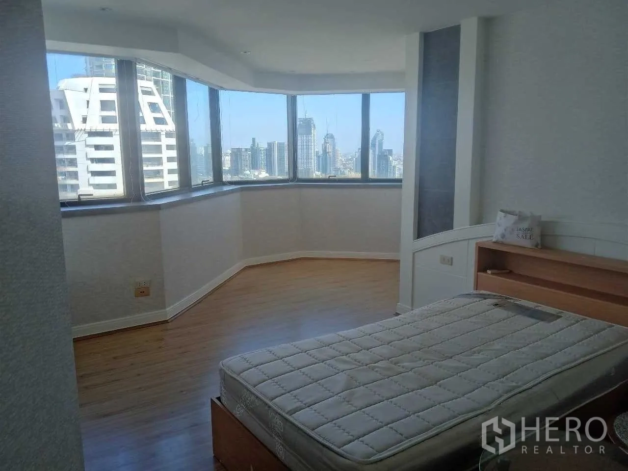 Condominium for rent in Khlong Toei, Bangkok - Corner bedroom with bay windows and panoramic skyline outlook.
