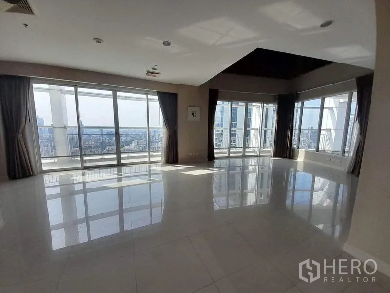 Condominium for rent or sale in Pathum Wan, Bangkok - Corner living room with floor‑to‑ceiling windows and sweeping skyline views.