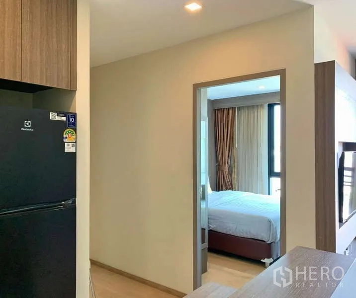 Condominium for rent - Hallway from kitchen to a bedroom with natural light and curtains.
