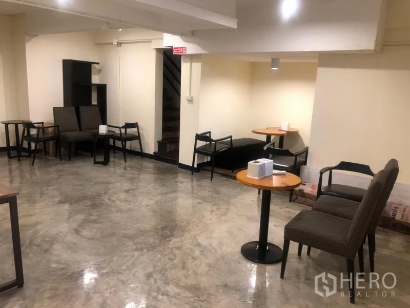Shophouse for rent in Watthana, Bangkok - Open dining space with polished concrete floor, neutral walls and movable tables and chairs.