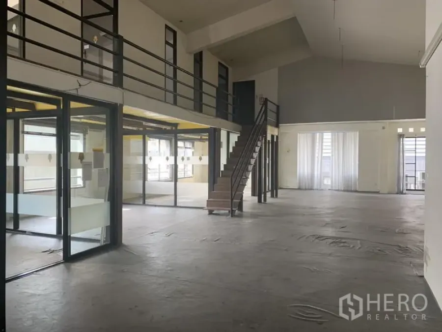 Retail Space for rent in Khlong Toei, Bangkok - Retail space featuring glass-walled rooms, mezzanine walkway and central staircase beneath a vaulted ceiling.