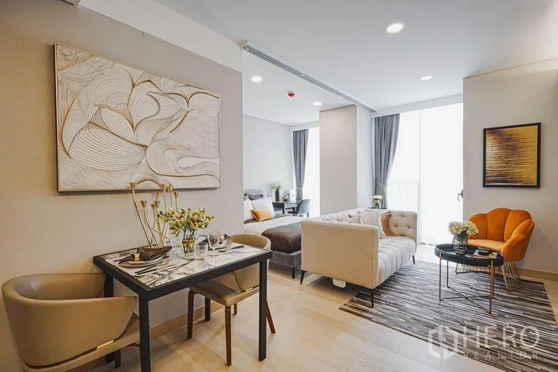 Condominium for sale in Khlong Toei, Bangkok - Intimate dining corner for two next to the lounge with large window and grey curtains.