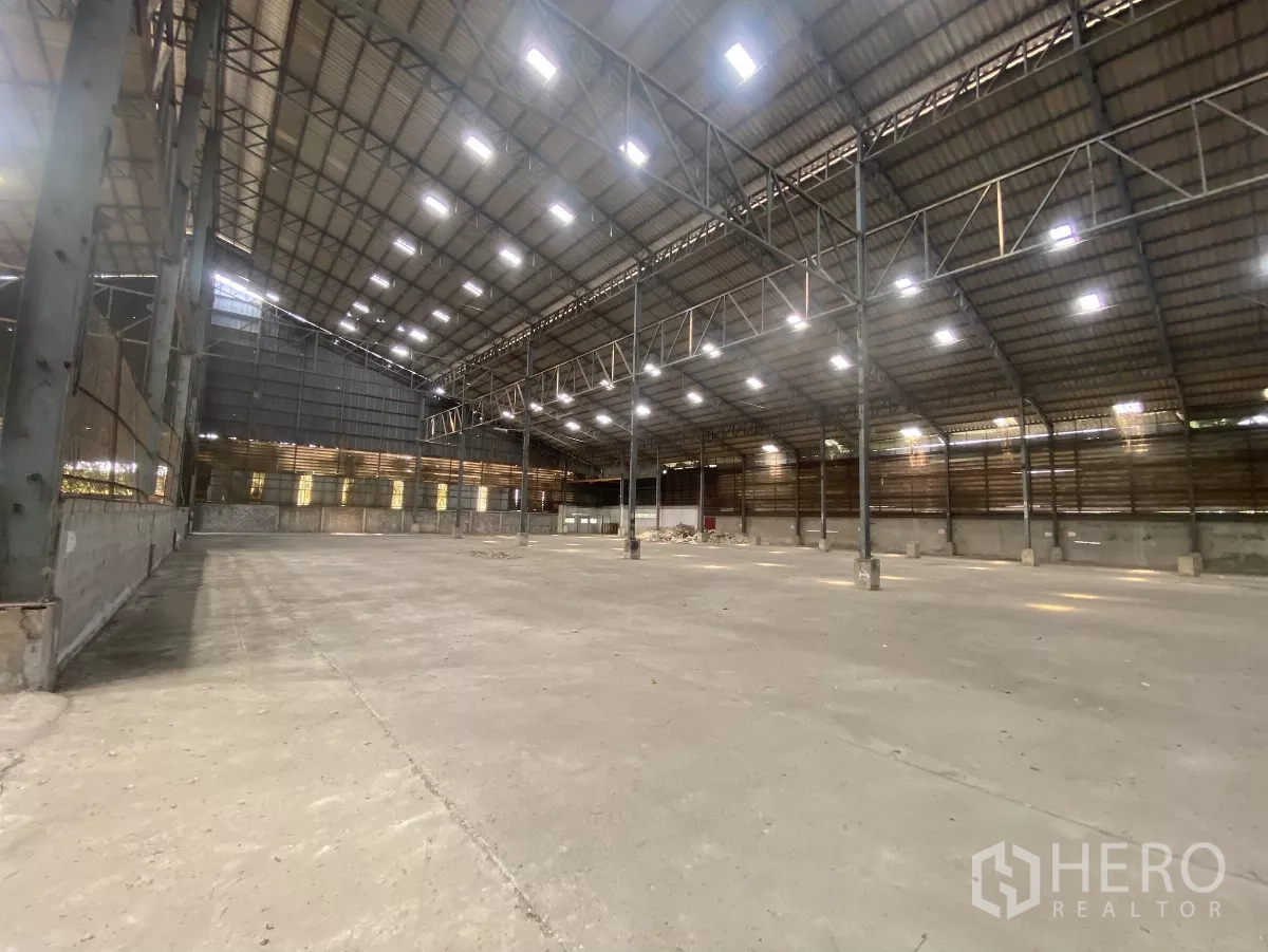 Factory for rent in Mueang Nakhon Pathom, Nakhon Pathom - Open factory hall with high clear height, steel columns, and concrete flooring.