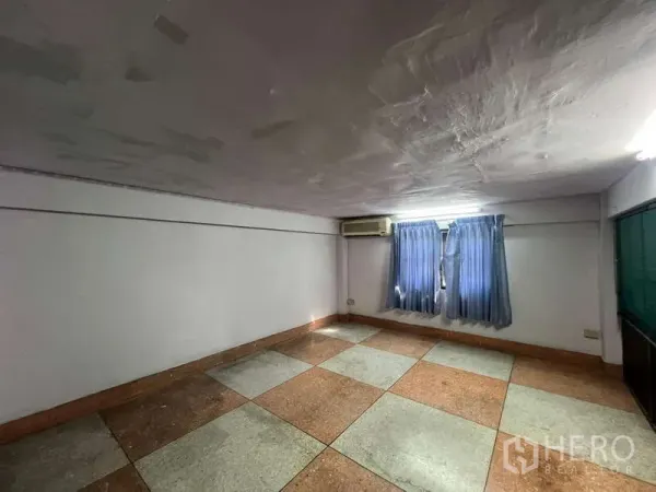 Shophouse for rent in Suan Luang, Bangkok - Compact office room with tiled floor, curtains and a wall-mounted air-conditioner.