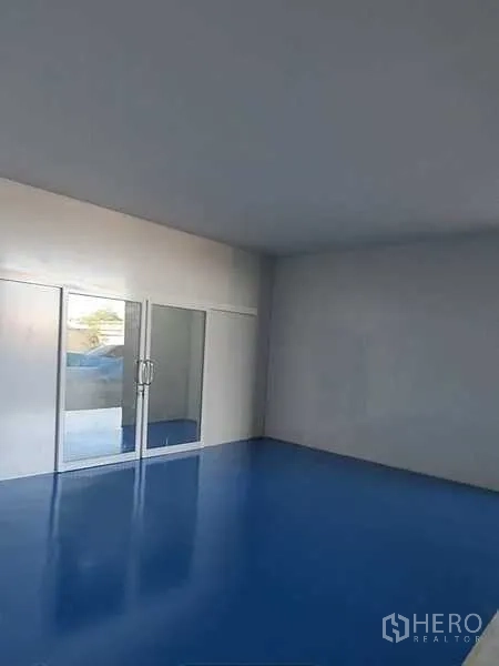 Factory for rent in Lam Luk Ka, Pathum Thani - Glass-partitioned office or meeting room with blue epoxy floor inside the factory.