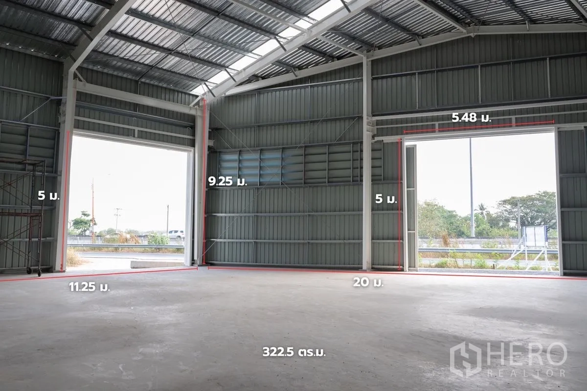 Warehouse for rent in Khlong Luang, Pathum Thani - High-clearance interior showing wide door openings and dimension labels on the walls.