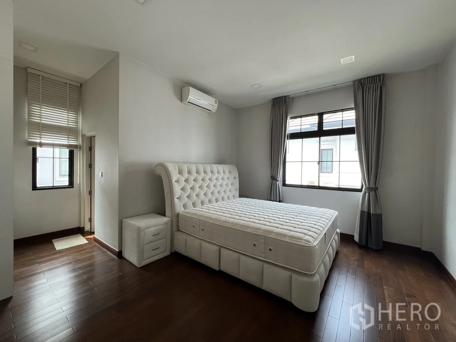 Detached House for rent or sale in Prawet, Bangkok - Bedroom with tufted bed, side table and large window.
